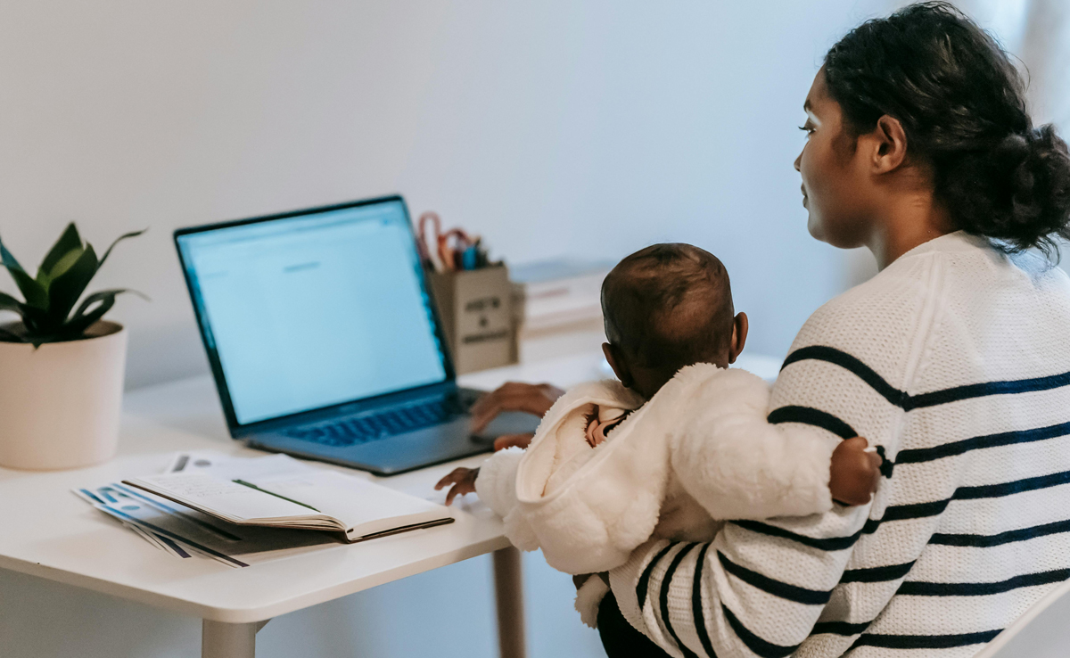Mom holding her baby sitting at her desk