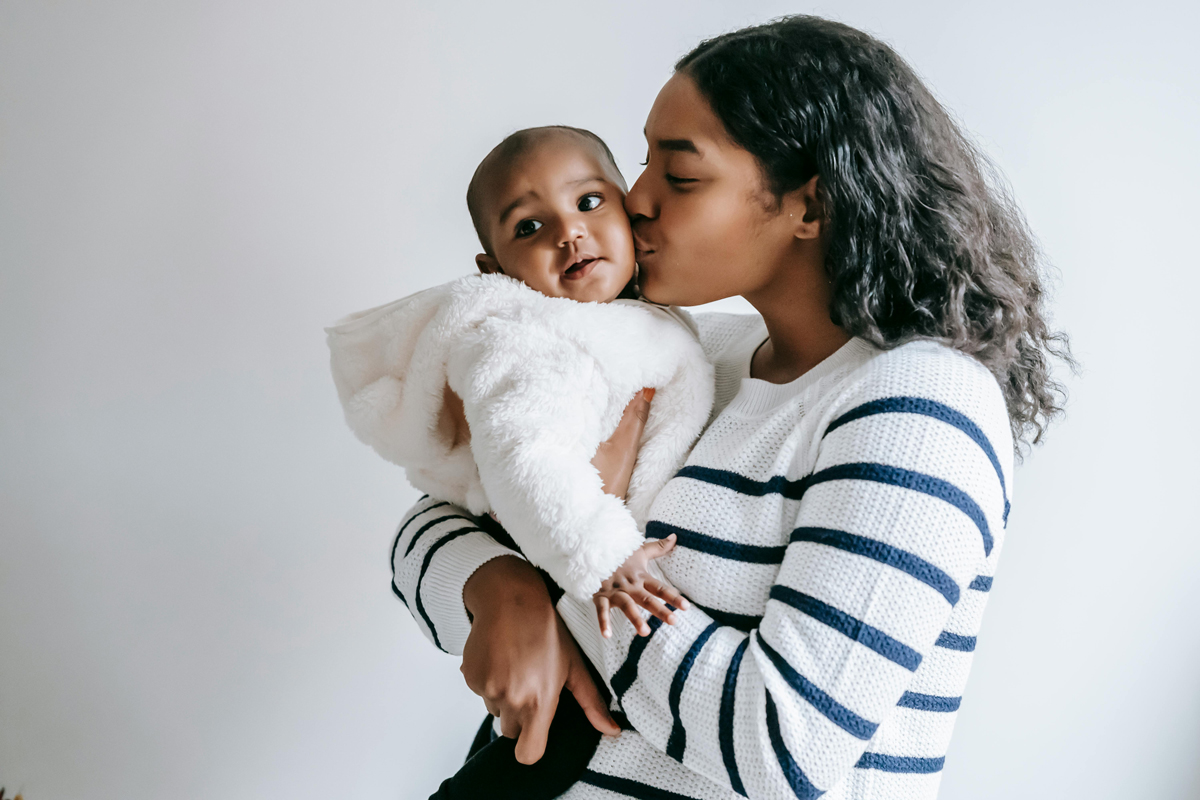 Mom holding and kissing her baby